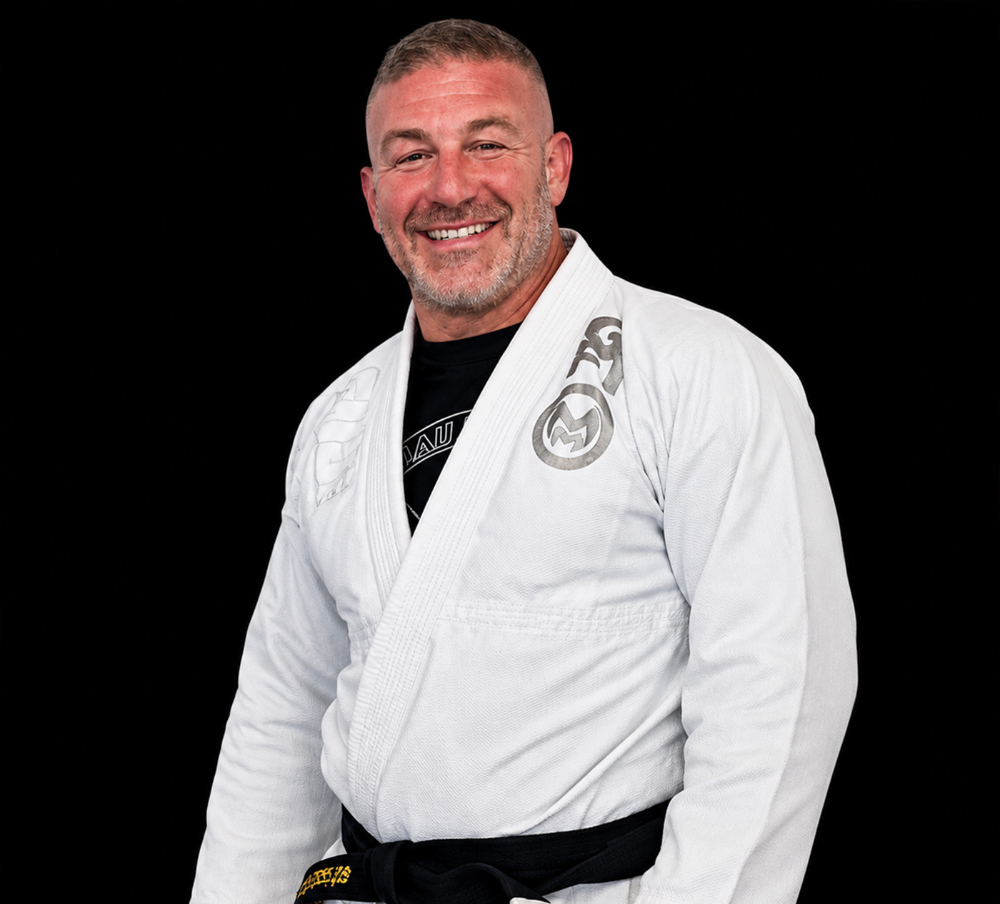 Coach Bobby McCarron smiling in a white gi and black belt.